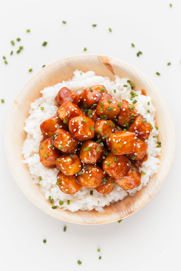 An overhead shot of a dish with white rice and general Tso's tofu on top