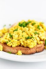 Close-up shot of tofu scramble on some bread topped with chopped chives