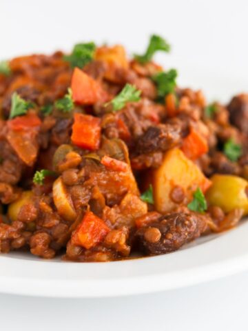 Close-up photo of a dish of vegan picadillo with some fresh herbs on top.