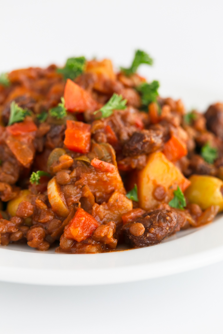 Close-up photo of a dish of vegan picadillo with some fresh herbs on top.