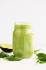 A side shot of a glass container with avocado smoothie
