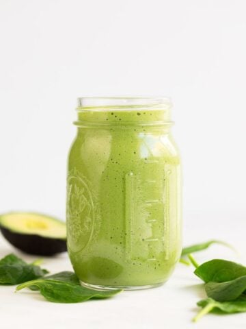 A side shot of a glass container with avocado smoothie