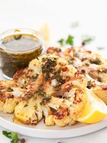 Close-up shot of a cauliflower steak with chimichurri on top