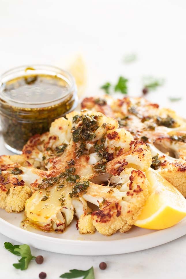 Close-up shot of a cauliflower steak with chimichurri on top