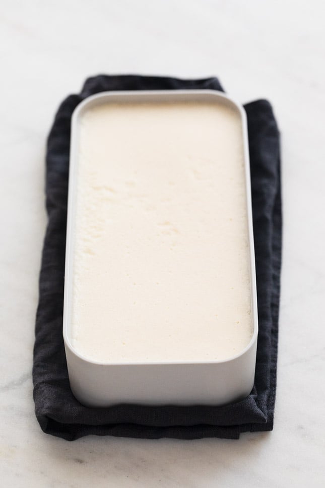 A container with some homemade vegan butter onto a white surface