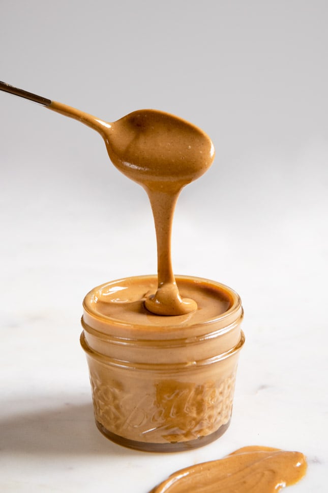 A side shot of a jar with cashew butter and a spoon