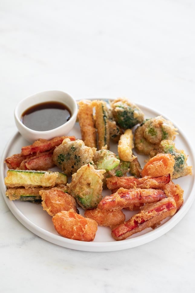 Photo of a plate of vegetable tempura and a small bowl with soy sauce