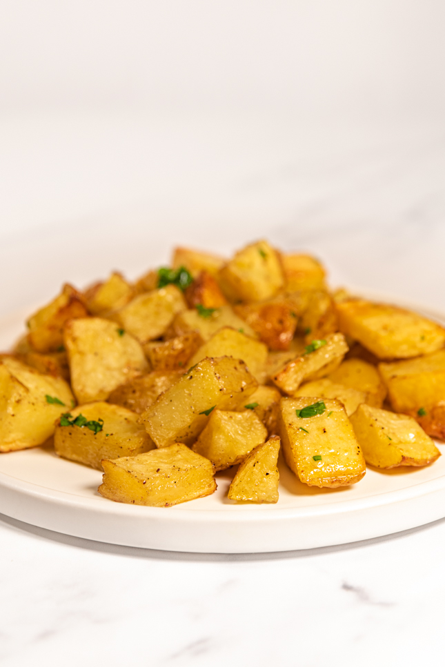 Side shot of a plate of roasted potatoes