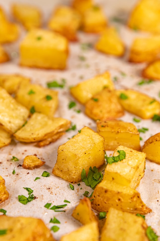 Close-up shot of a lined baking dish with roasted potatoes