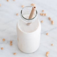 A square picture of a bottle with homemade soy milk