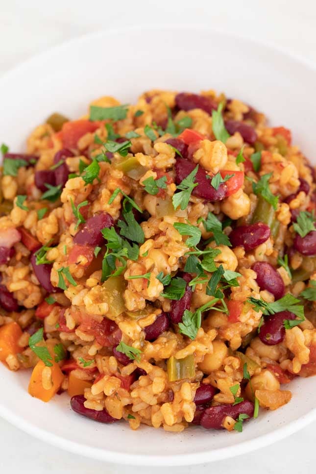 An overhead shot of a dish with vegan jambalaya and garnished with parsley