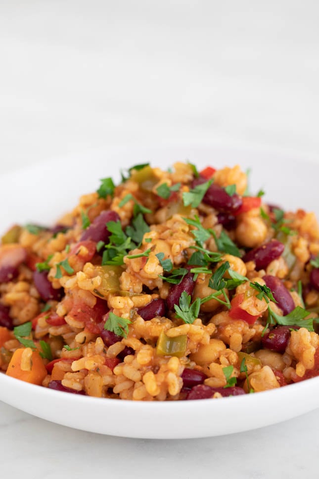 Picture of a dish with homemade vegan jambalaya topped with chopped parsley