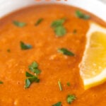 Close-up shot of a bowl of red lentil soup with the words red lentil soup