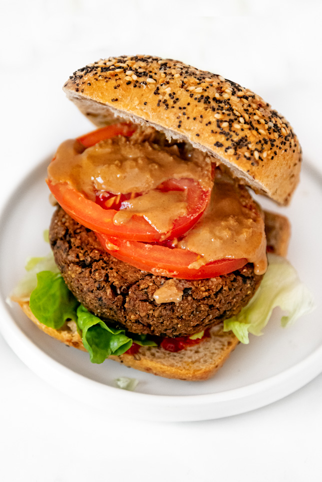Photo of a black bean burger with bread and toppings