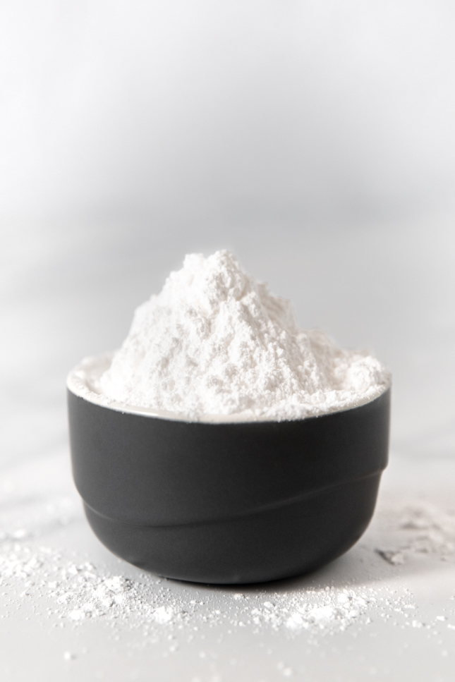 Side shot of a bowl of powdered sugar