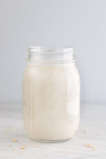 A side shot of a glass jar with homemade oat milk