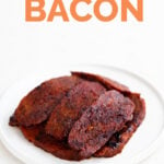 A picture of a white dish with some cooked vegan bacon slices with the words vegan bacon