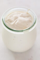 A close shot of a glass jar filled with homemade vegan sour cream