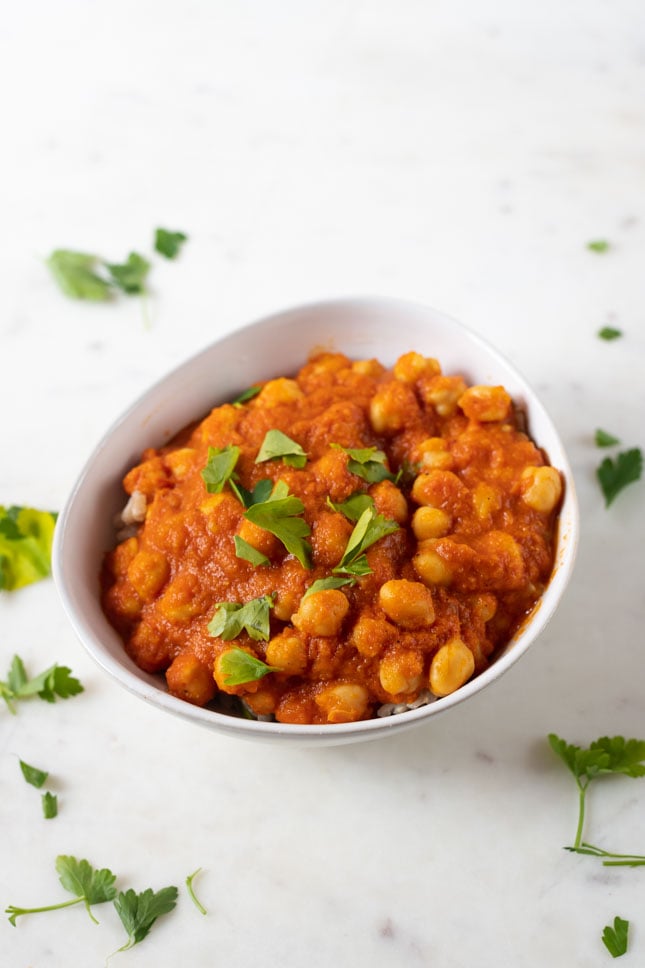 An overhead shot of a bowl with Indian chana masala garnished with chopped parsley