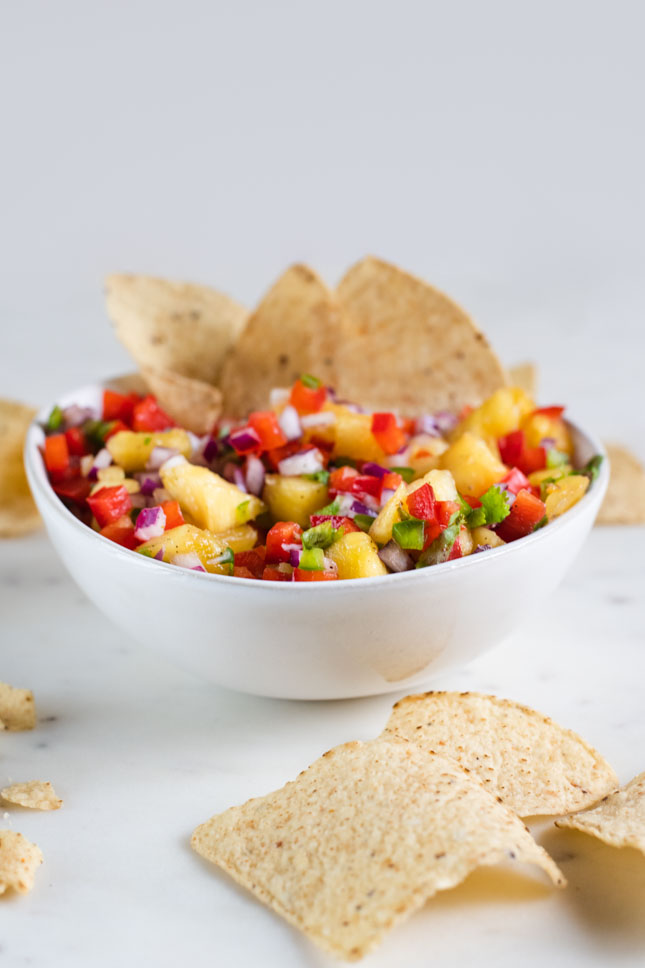 A picture of a bowl of pineapple salsa with nachos