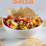 A picture of a bowl of pineapple salsa with nachos with the words pineapple salsa
