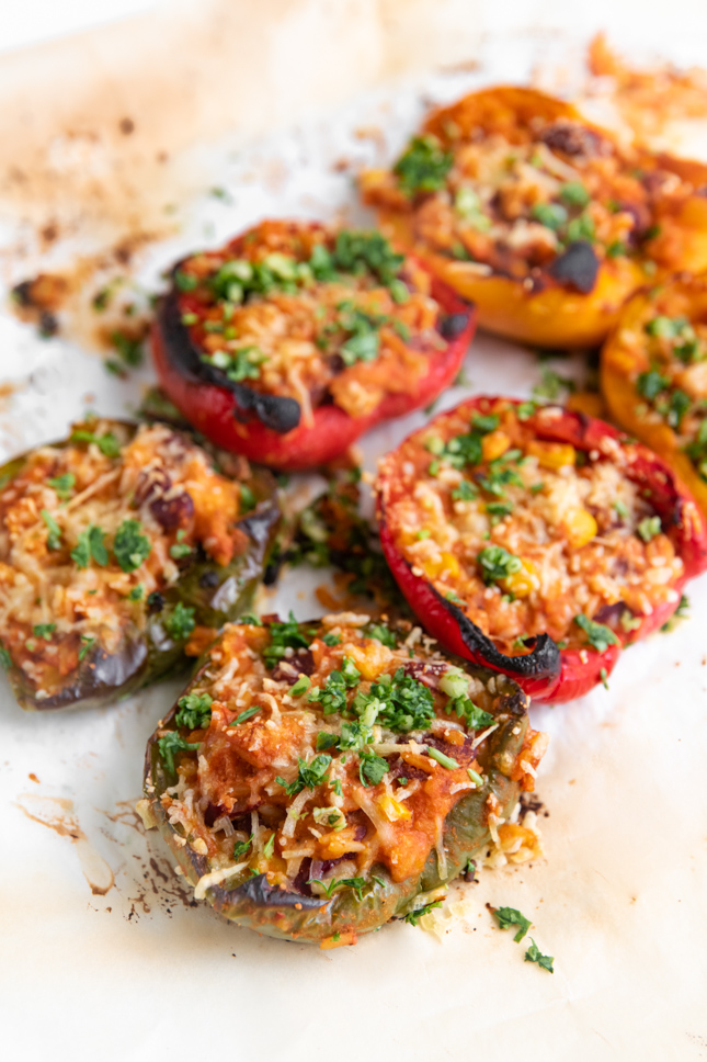 Photo of 6 halved vegan stuffed peppers on a plate