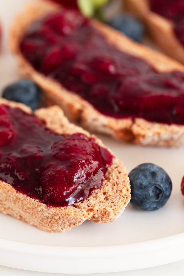 A close shot of a dish with bread sliced spread with berry compote