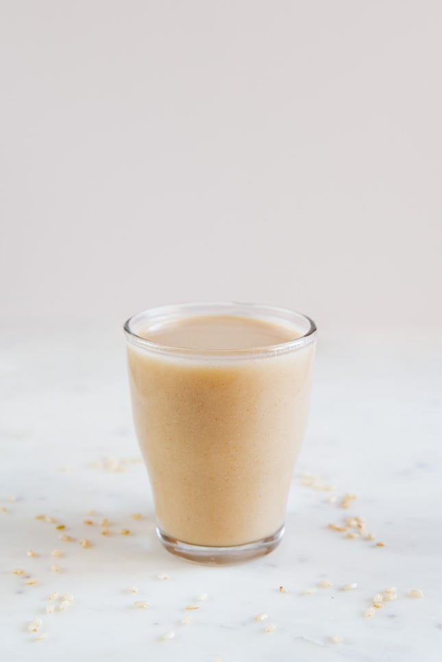 A side shot of a glass with brown rice milk made from scratch