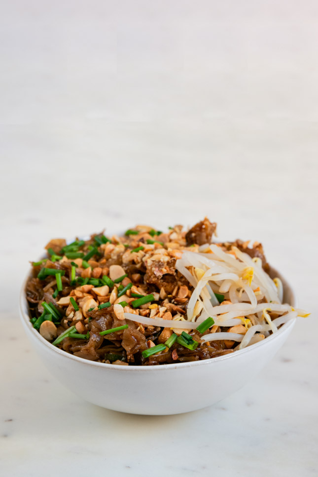 A picture of a bowl with homemade vegan pad Thai with toppings
