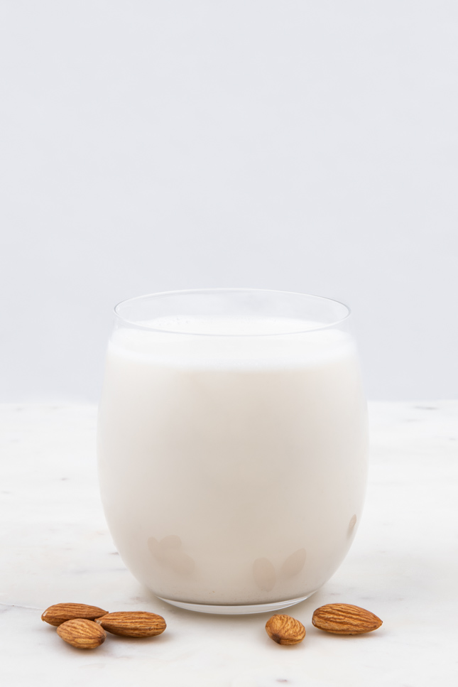 Side shot of a glass of homemade almond milk