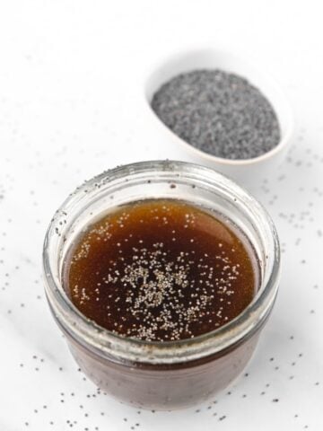 Photo of a small glass jar of poppy seed dressing