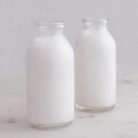 Square photo of two glass bottles of coconut milk