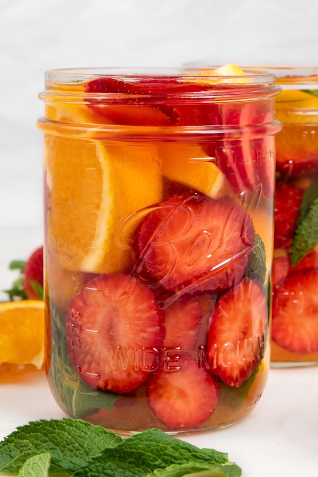 Close-up side shot of a glass jar of fruit infused water