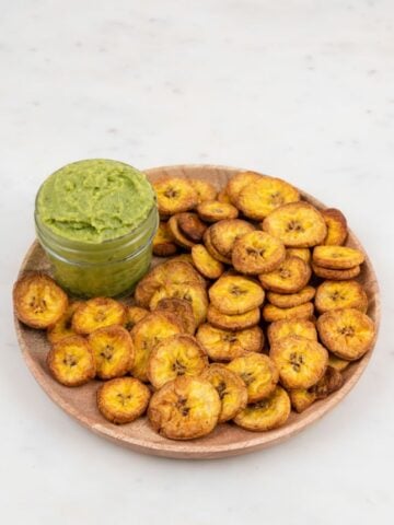 Photo of a plate of plantain chips with guacamole in a bowl
