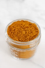 Photo of a small glass jar of curry powder