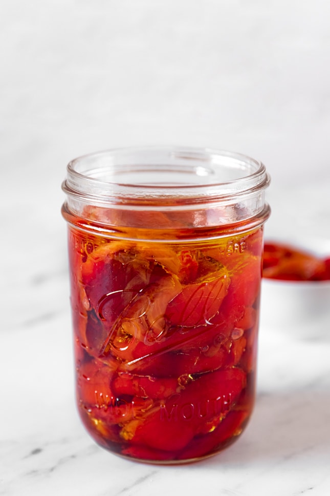 Photo of a glass jar with some roasted red peppers