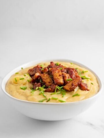Photo of a bowl of vegan potato soup topped with tempeh bacon