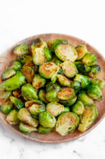 Photo of a wooden plate of sauteed Brussels sprouts
