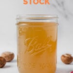 Side photo of a glass jar of vegetable stock with the words how to make vegetable stock