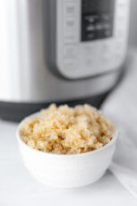 Photo of a bowl of Intant Pot quinoa in front of an Instant Pot