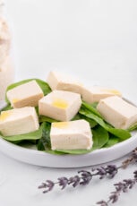 Photo of some vegan feta cheese over a salad