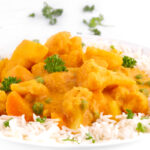 Close-up photos of a plate of vegetable korma with a title