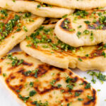 Close-up photo of some slices of vegan naan with a title