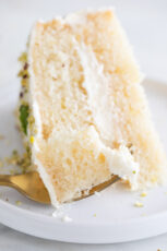 Close-up photo of a dish with a slice of vegan lemon cake and a fork