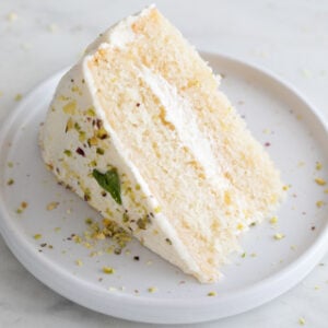 Square photo of a slice of vegan lemon cake onto a dish