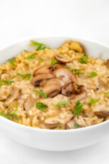 Photo of a dish with vegan mushroom risotto with some chopped parsley on top