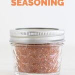 Side photo of a closed jar with homemade Cajun seasoning with a heading