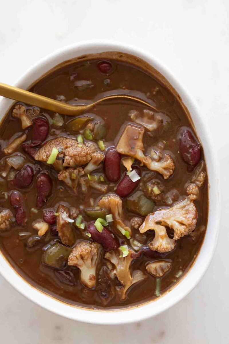 Photo from above of a bowl with vegan gumbo and a golden spoon