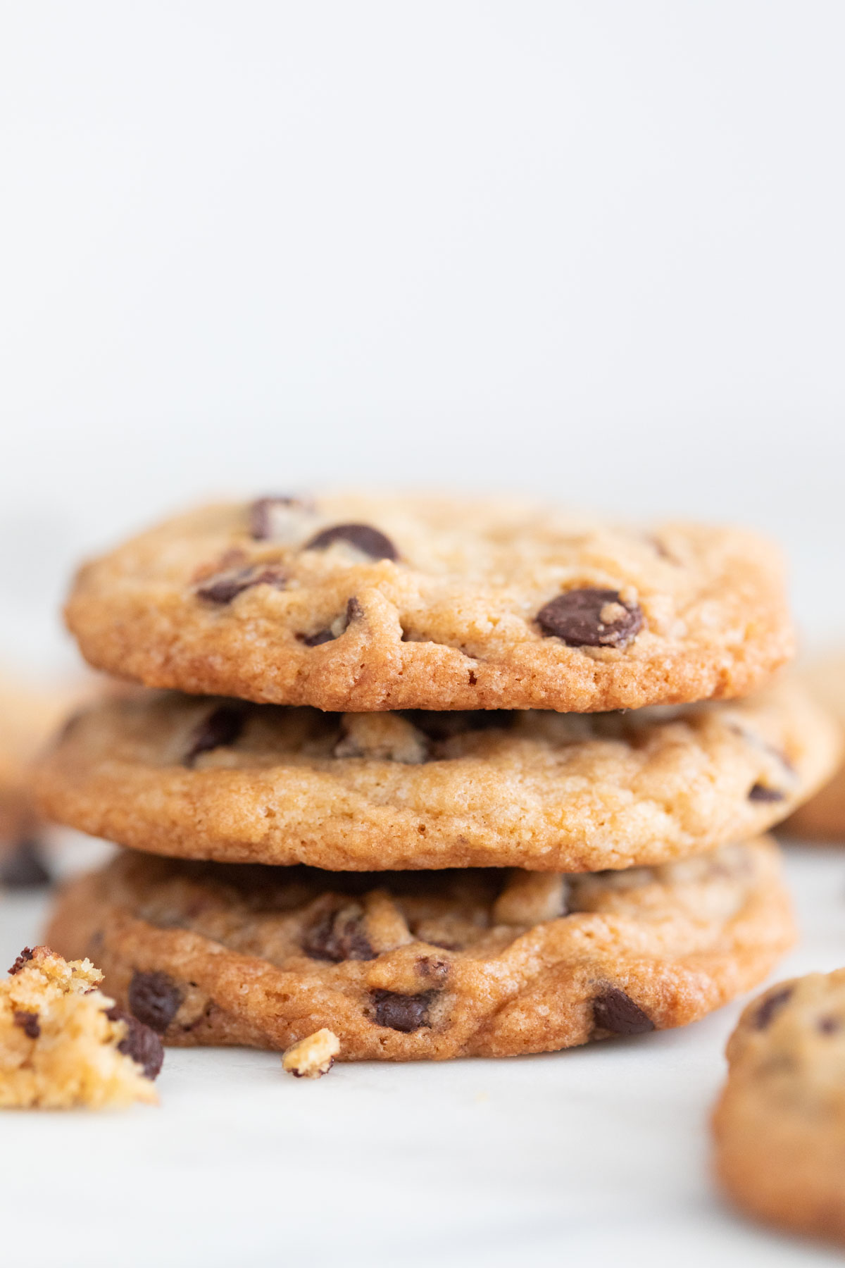 Three vegan chocolate chip cookies stacked up.