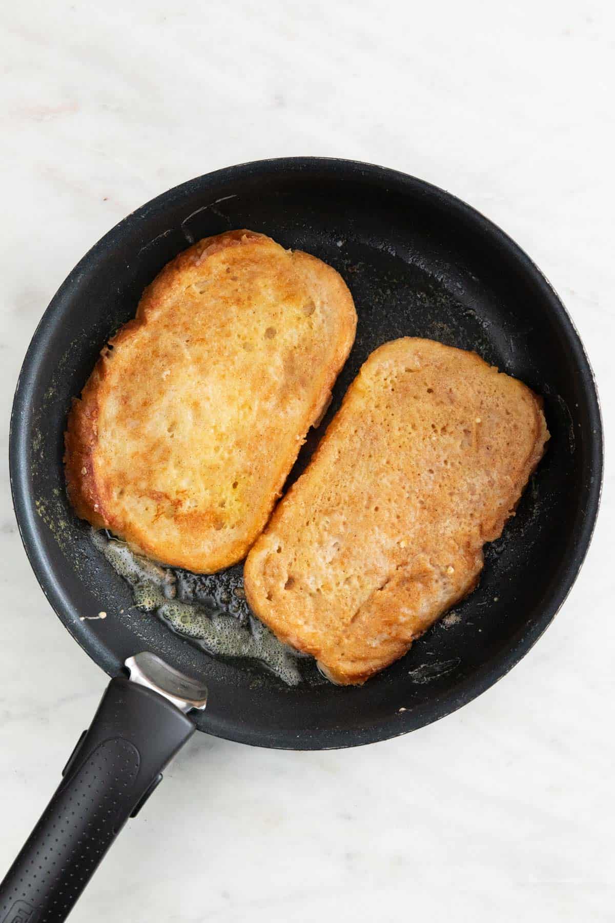 Vegan French toast frying in a skillet.
